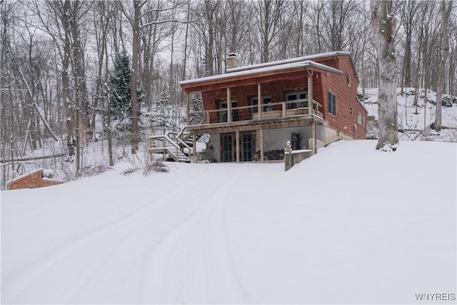 view of snow covered back of property