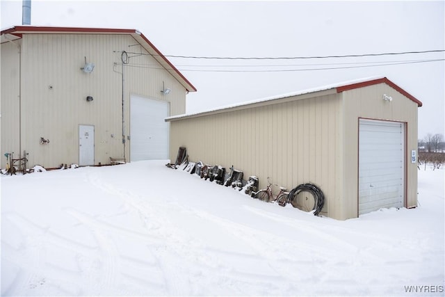 snow covered structure with a garage