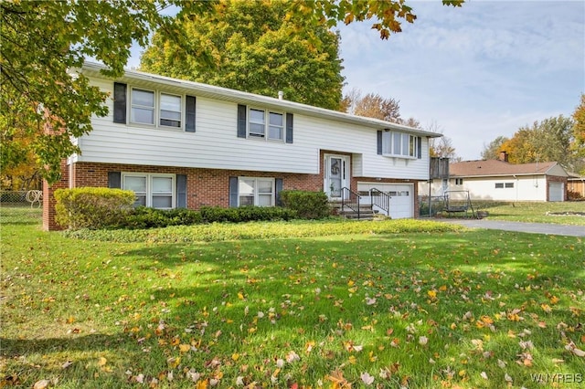 raised ranch featuring a garage and a front yard