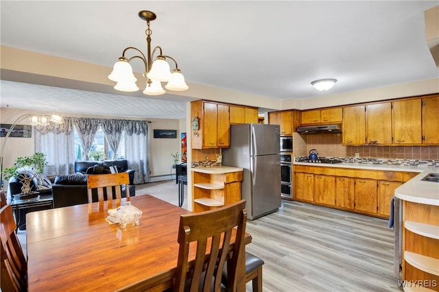 dining space with an inviting chandelier and light hardwood / wood-style floors