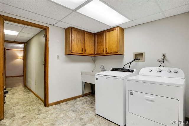 laundry area with cabinets, washer and clothes dryer, and sink