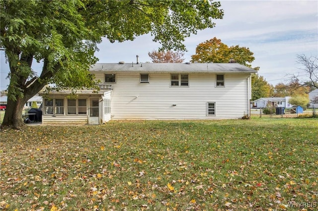 back of house featuring a sunroom and a lawn