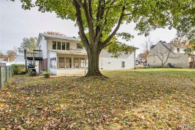 rear view of house with a yard and a sunroom