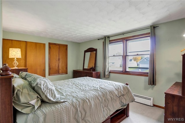 bedroom with a baseboard radiator and light carpet