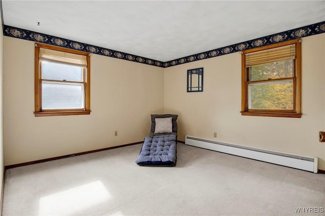 unfurnished room featuring a baseboard radiator, plenty of natural light, and carpet flooring