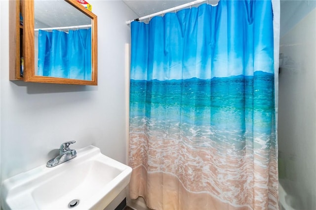 bathroom featuring sink and curtained shower