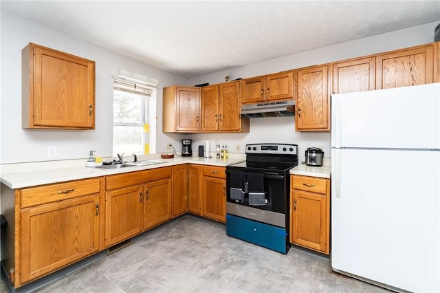 kitchen with electric stove, sink, and white fridge