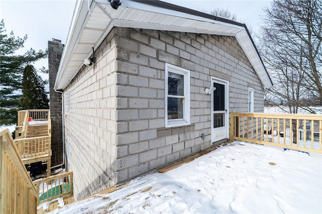 view of snowy exterior featuring a deck