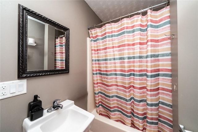 bathroom featuring shower / tub combo, sink, and a textured ceiling