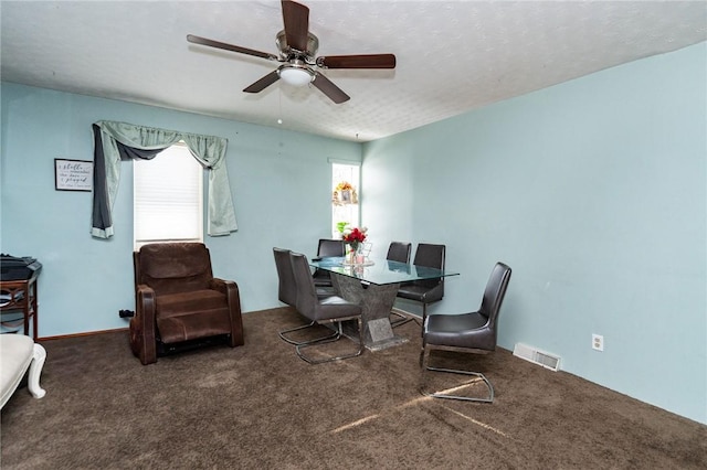 dining space with dark colored carpet, a textured ceiling, and ceiling fan