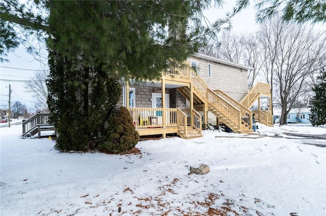 view of snow covered back of property