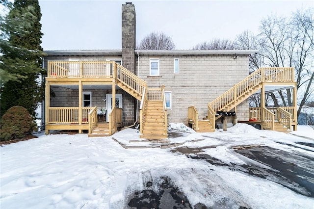 snow covered house featuring a deck