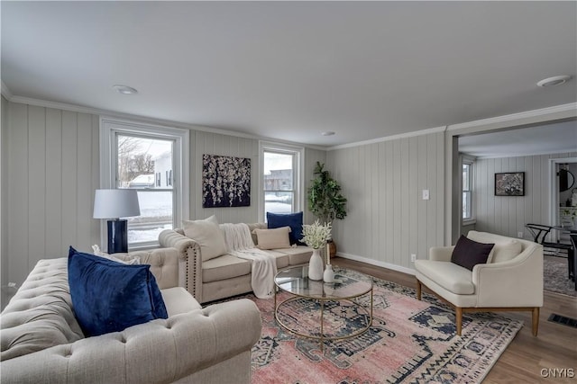 living room featuring crown molding, a wealth of natural light, and light hardwood / wood-style flooring