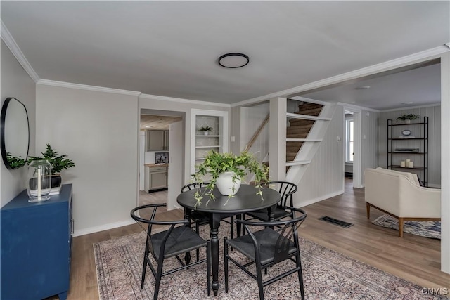 dining area featuring hardwood / wood-style floors and crown molding