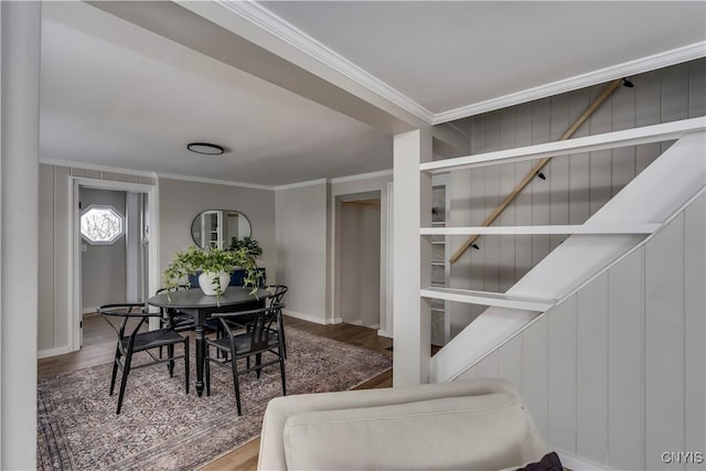 dining space with hardwood / wood-style flooring and ornamental molding