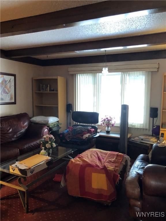 living room featuring beam ceiling and plenty of natural light