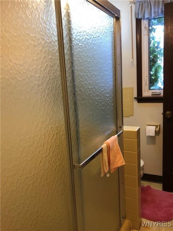 bathroom featuring an enclosed shower and toilet