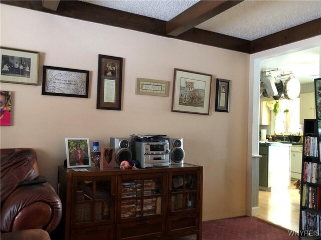 interior space featuring beam ceiling and a textured ceiling