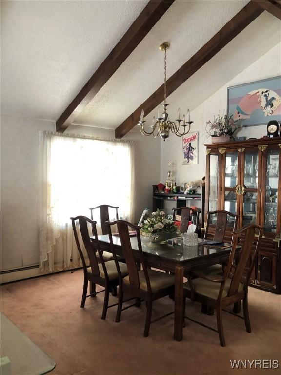 dining space featuring carpet, vaulted ceiling with beams, and a chandelier