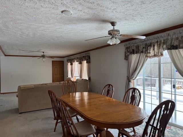 dining space featuring ornamental molding, light carpet, and a textured ceiling