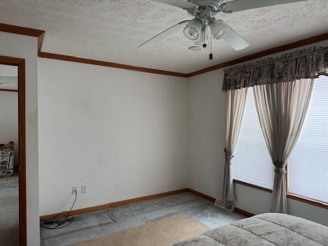 unfurnished bedroom with ornamental molding, light carpet, ceiling fan, and a textured ceiling