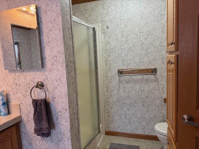 bathroom with vanity, an enclosed shower, and toilet