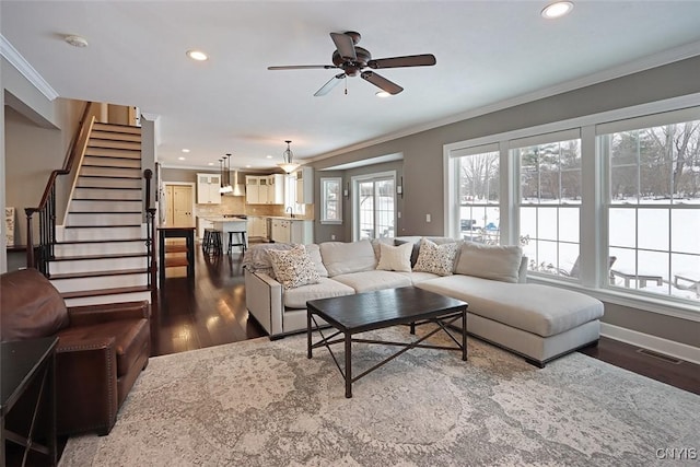 living room with dark wood-type flooring, ceiling fan, and ornamental molding