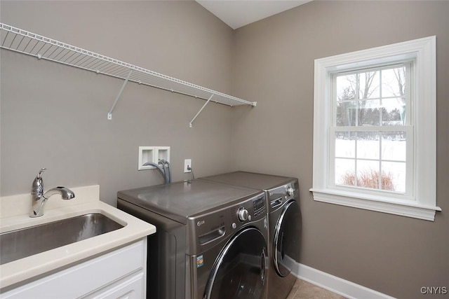 laundry area with cabinets, independent washer and dryer, a healthy amount of sunlight, and sink