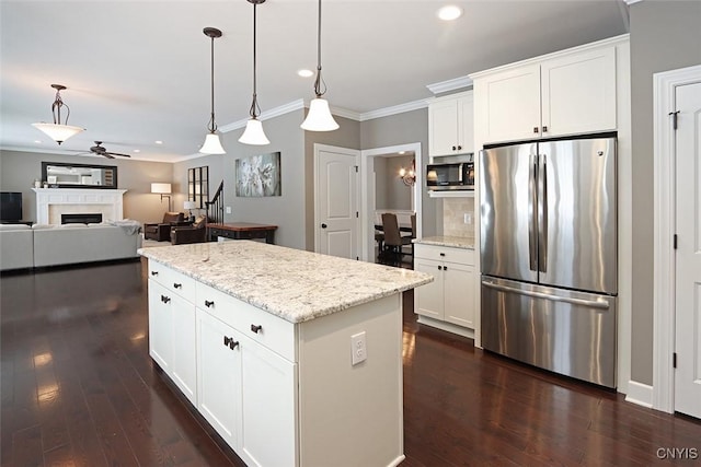 kitchen with white cabinetry, hanging light fixtures, and stainless steel appliances