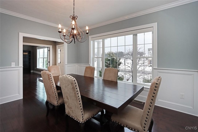 dining space with crown molding, dark hardwood / wood-style flooring, and an inviting chandelier