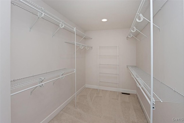 walk in closet featuring light colored carpet