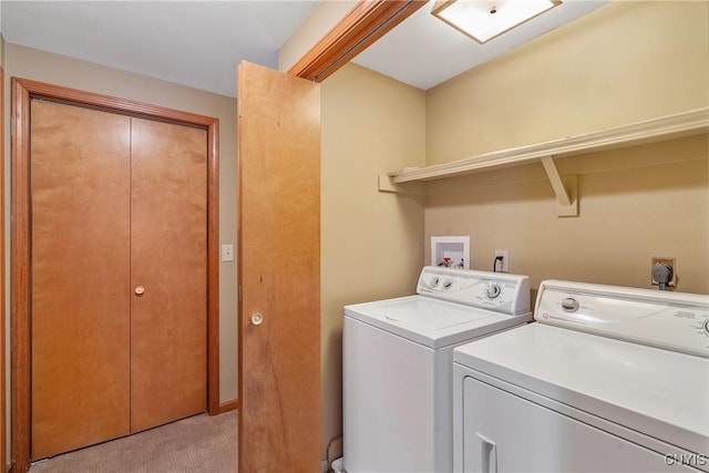 clothes washing area with washing machine and clothes dryer and light colored carpet