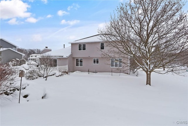 view of snow covered back of property