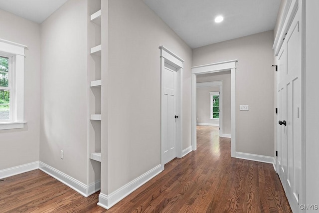 hallway featuring dark hardwood / wood-style flooring and built in features