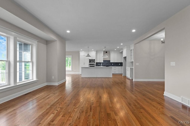 unfurnished living room with wood-type flooring