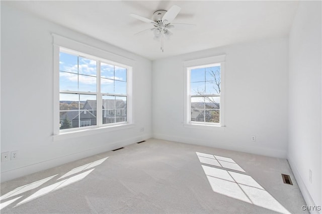 carpeted spare room with ceiling fan