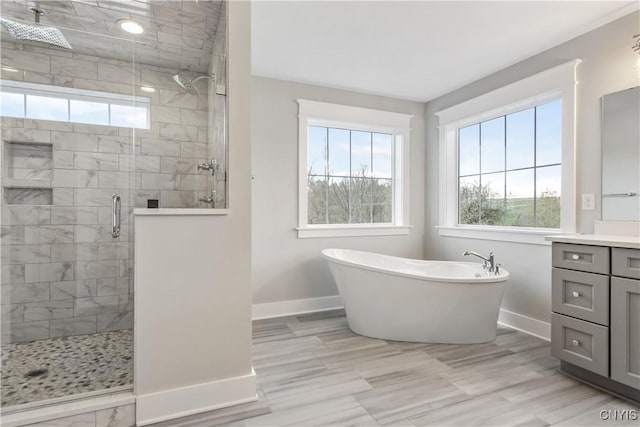 bathroom featuring vanity, separate shower and tub, and a healthy amount of sunlight