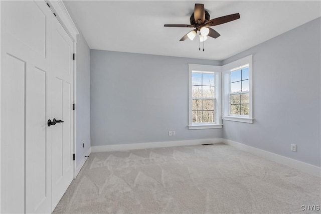 empty room featuring light colored carpet and ceiling fan