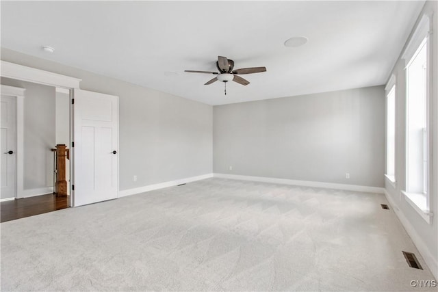 empty room with ceiling fan and light carpet