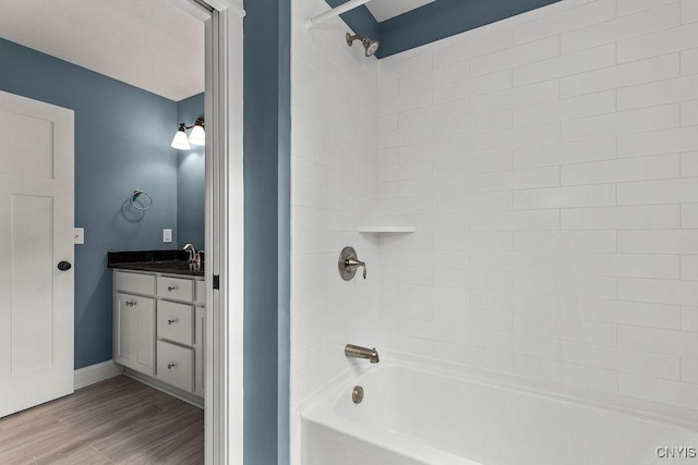 bathroom featuring hardwood / wood-style flooring, vanity, and tiled shower / bath combo