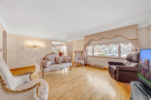 living room with hardwood / wood-style floors and crown molding