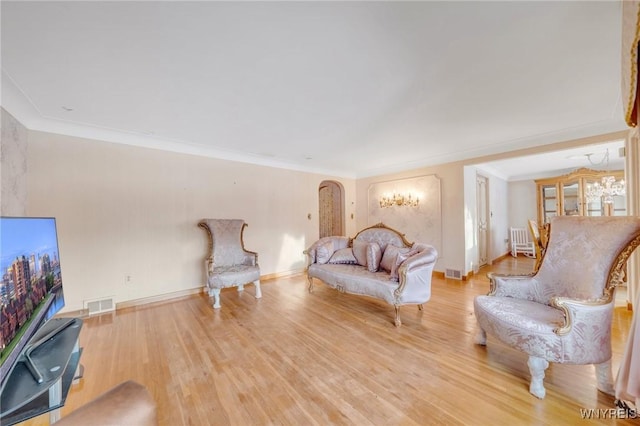 living room featuring crown molding and light wood-type flooring