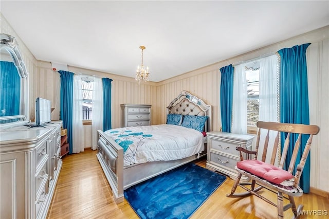 bedroom featuring an inviting chandelier and light wood-type flooring