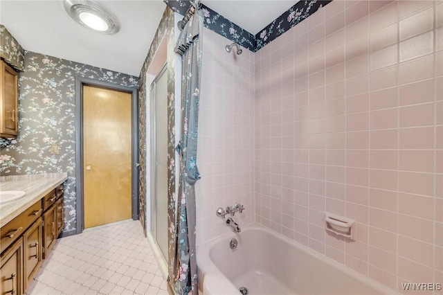 bathroom featuring vanity and tiled shower / bath