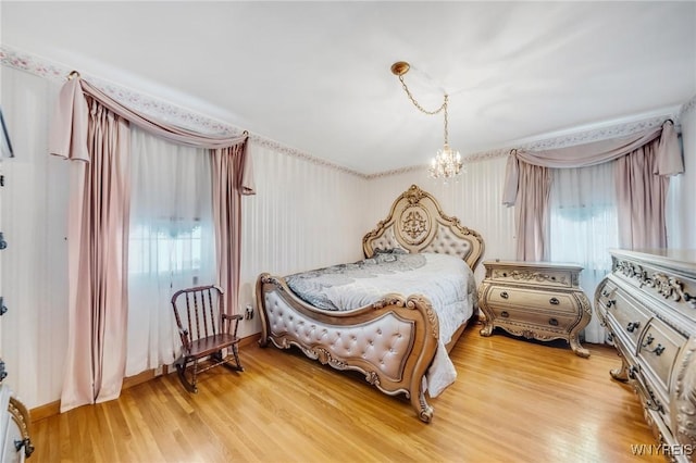 bedroom featuring hardwood / wood-style floors and a chandelier