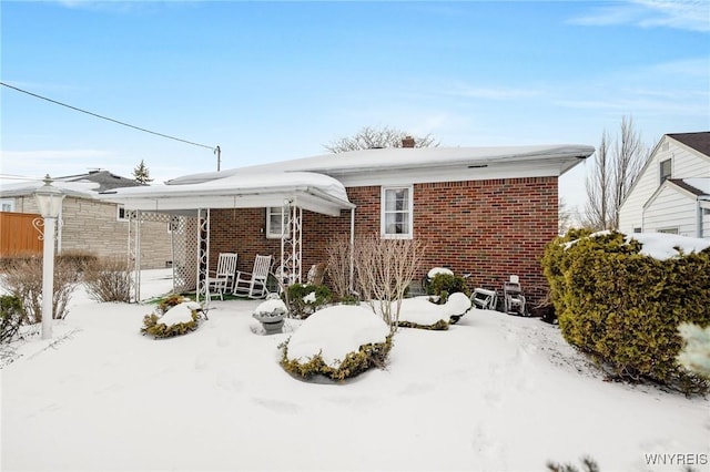 view of snow covered rear of property