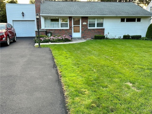 ranch-style house featuring a garage and a front lawn