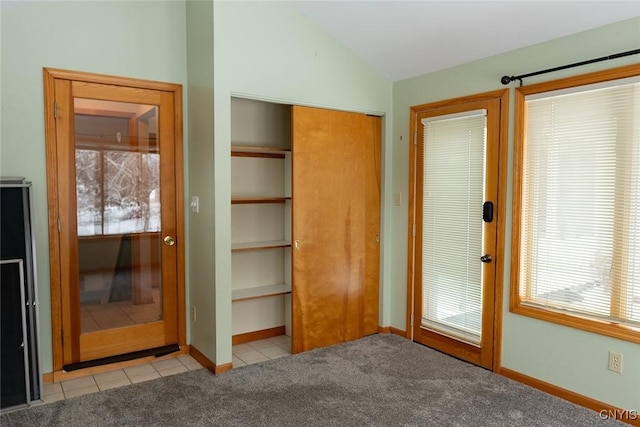 interior space with light carpet, lofted ceiling, and a closet