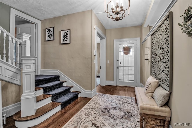 foyer entrance featuring dark hardwood / wood-style floors and an inviting chandelier