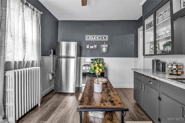 interior space with dark hardwood / wood-style flooring, radiator heating unit, stainless steel refrigerator, and gray cabinets